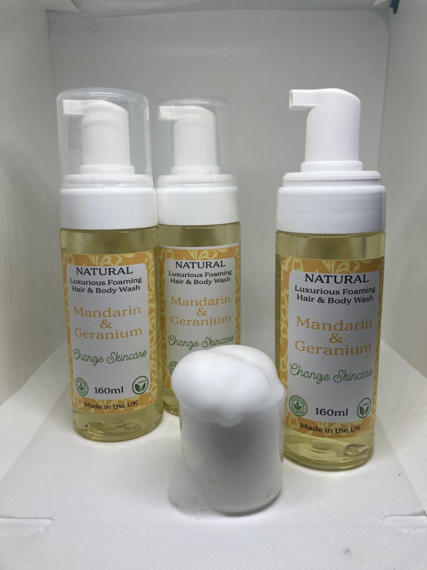 3 plastic bottles containing foaming hair and body wash with labels. Text on label reads Natural luxurious hair and body wash. Mandarin & Geranium. Change skincare. 160ml made in the UK